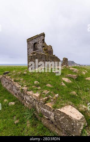 Les vieilles ruines en pierre du village de Highfield, dans la ville de Stanley en Tasmanie, sont vues depuis une basse perspective sur un knoll herbacé Banque D'Images