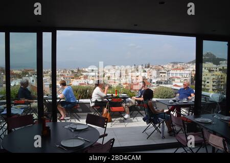 Les touristes s'assoient sur la terrasse du restaurant sur le toit de l'hôtel Athènes était design à Athènes, Grèce. Banque D'Images