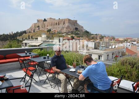 Les touristes s'assoient à une table avec une vue sur l'Acropole sur le toit de l'hôtel Athènes était à Athènes, Grèce. Banque D'Images