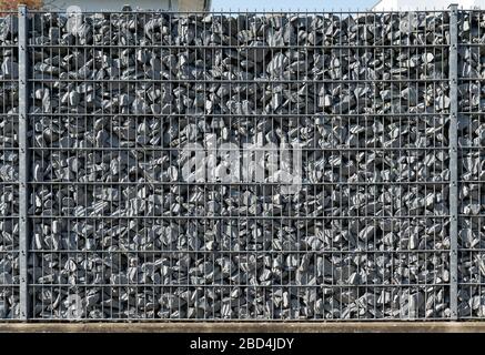 Une clôture de fil remplie de pierres crée un mur de Gabionen. Banque D'Images