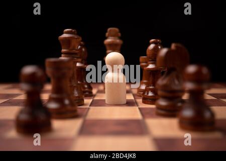 Les personnages en bois (homme d'affaires) qui se tiennent face au roi des échecs et qui sont dans le cercle des échecs. Les nouveaux acteurs commerciaux sont confrontés à des défis. La direction Banque D'Images