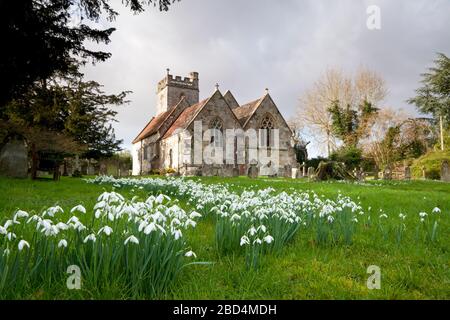 Chutes de neige dans le jardin de la cour de l'église Saint-Georges de Fovant, dans le Wiltshire. Banque D'Images