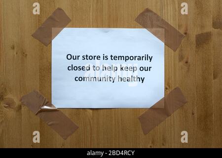 un panneau attaché à la porte avec les mots "notre magasin est temporariouly fermé pour aider à garder notre communauté immobilière" Banque D'Images