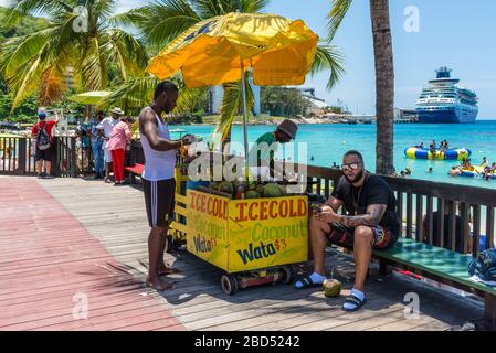 Ocho Rios, Jamaïque - 22 avril 2019: Le vendeur de noix de coco prépare la noix de coco près de la plage de Fisherman's Beach à Ocho Rios, Jamaïque. Les gens aiment les noix de coco Banque D'Images