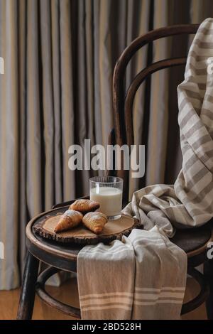 Croissants et lait servis sur une ancienne chaise dans la chambre Banque D'Images