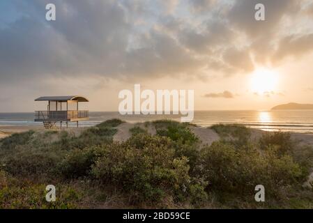 Une station de sauveteurs au soleil tôt le matin à Bennetts Beach, Hawks Nest sur la côte du milieu-nord de la Nouvelle-Galles du Sud, en Australie Banque D'Images