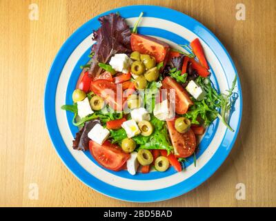 Salade avec fromage feta et olives vertes vues de dessus sur une table de cuisine en bois Banque D'Images