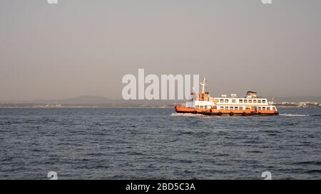 Ferry pour passagers de Lisbonne, Portugal. Les couleurs orange et blanc du traversier de passagers de banlieue traversant le Tage au crépuscule. Banque D'Images