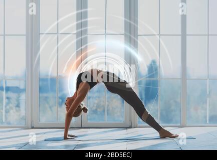 Jeune femme sportive pratiquant le yoga, faisant l'exercice de pont sur fond de grande fenêtre Banque D'Images