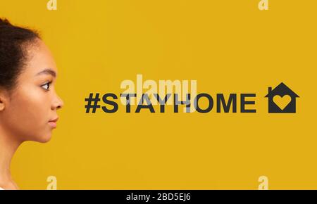Campagne pandémique COVID-19. Afro-américaine femme et hashtag RESTER À LA MAISON sur fond orange, collage Banque D'Images