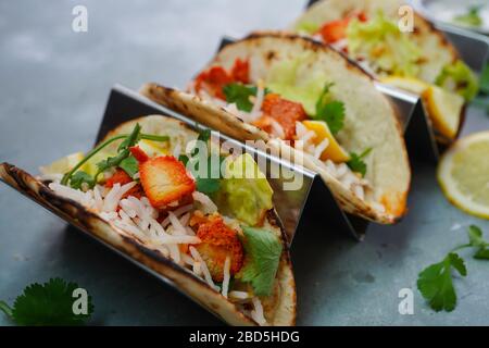 Poulet maison Tikka Tacos servi dans un support en métal Taco, foyer sélectif Banque D'Images