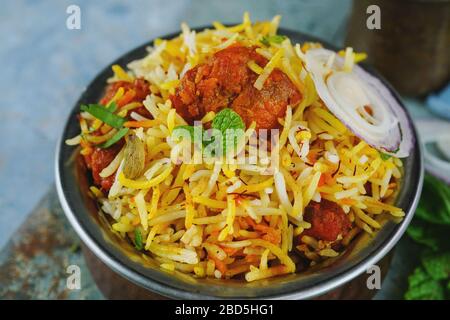 Tikka Biryani, poulet maison, servi dans un récipient traditionnel en laiton avec sauce au yaourt, foyer sélectif Banque D'Images