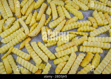 Frites surgelées sur du papier de renfort prêt à être cuit au four. Banque D'Images