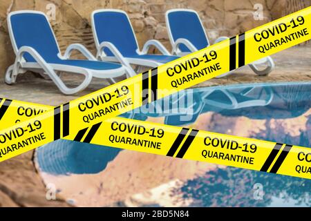 Risque biologique bandes d'avertissement de Coronavirus contre trois chaises longues et piscine d'eau bleue, Egypte. Quarantaine. Pandémie mondiale COVID-19, 2019 Banque D'Images