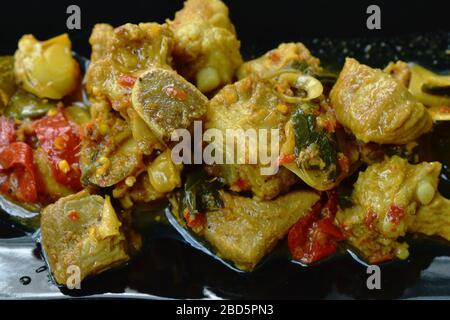 Épicé sauté d'os de porc frit ou de côtes avec des herbes dans le curry jaune du sud de la cuisine thaïlandaise sur plaque Banque D'Images