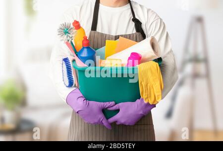 Homme dans un bol de maintien uniforme avec divers outils de nettoyage Banque D'Images