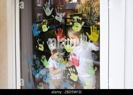 Les enfants peignent avec des palmiers sur la fenêtre. Quarantaine Banque D'Images