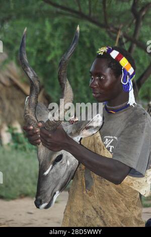 Portrait d'un jeune Hadzabe (Hadza) homme. Photographe au lac Eyasi, Tanzanie Banque D'Images