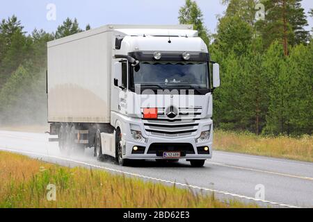 La semi-remorque blanche Mercedes-Benz Actros K Grahn transporte la charge sur la Highway 25 un jour pluvieux de l'été. Raasepori, Finlande. 5 juillet 2019. Banque D'Images