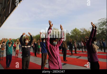 Delhi, Inde. 7 avril 2020. Les travailleurs salariés et les sans-abri font du yoga au complexe sportif Yamuna, qui a été transformé en camp de fortune pour ceux qui sont bloqués à Delhi sans domicile au cours d'un verrouillage national à la suite de la pandémie de coronavirus. Le gouvernement indien a imposé un verrouillage national de 21 jours pour réduire au minimum la propagation de la maladie de Coronavirus (Covid-19). Crédit: SOPA Images Limited/Alay Live News Banque D'Images