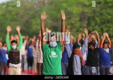 Delhi, Inde. 7 avril 2020. Les travailleurs salariés et les sans-abri font du yoga au complexe sportif Yamuna, qui a été transformé en camp de fortune pour ceux qui sont bloqués à Delhi sans domicile au cours d'un verrouillage national à la suite de la pandémie de coronavirus. Le gouvernement indien a imposé un verrouillage national de 21 jours pour réduire au minimum la propagation de la maladie de Coronavirus (Covid-19). Crédit: SOPA Images Limited/Alay Live News Banque D'Images