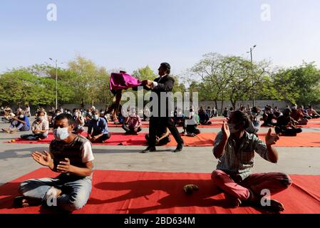 Delhi, Inde. 7 avril 2020. Un magicien se produit à partir de travailleurs salariés et sans abri au cours d'une séance de yoga au complexe sportif Yamuna qui a été transformé en camp de fortune pour ceux qui se sont retrouvés à Delhi sans domicile pendant un verrouillage national à la suite d'une pandémie de coronavirus. Le gouvernement indien a imposé un verrouillage national de 21 jours pour réduire au minimum la propagation de la maladie de Coronavirus (Covid-19). Crédit: SOPA Images Limited/Alay Live News Banque D'Images