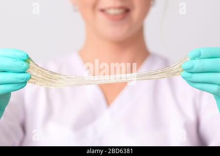 Cosmetologist détient de pâte ou de sucre miel cire pour les cheveux de la dépose d'une gants médicaux, Close up. Banque D'Images