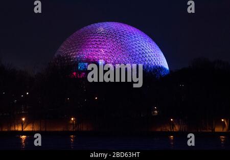 Montréal, Canada. 06 avril 2020. La biosphère de Montréal, Québec, Canada, est illuminée dans des couleurs arc-en-ciel, le lundi 6 avril 2020, alors que les cas de Coronavirus COVID-19 augmentent au Canada et dans le monde entier. Crédit : Graham Hughes/Alay Live News Banque D'Images