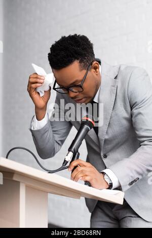 haut-parleur africain sueur nerveux avec serviettes et microphone lors d'une conférence d'affaires au bureau Banque D'Images