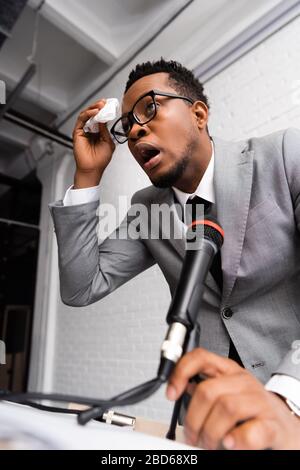 haut-parleur africain sueur nerveux avec serviettes et microphone lors d'une conférence d'affaires au bureau Banque D'Images