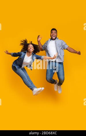 Un couple africain heureux qui se trompe ensemble, Jumping High on Air dans Studio Banque D'Images