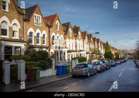 Une rue de maisons britanniques typiques avec parking sur la rue Banque D'Images