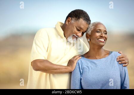 Happy senior couple heureusement debout sur une plage. Banque D'Images