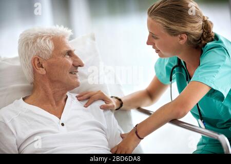 Portrait d'un homme dans un lit d'hôpital, et une jeune femme médecin. Banque D'Images