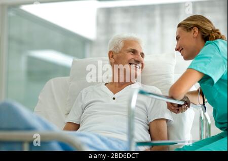 Portrait d'un homme dans un lit d'hôpital, et une jeune femme médecin. Banque D'Images