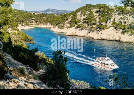 Vue sur la Calanque de Port PIN avec un bateau touristique, Parc National de Calanques, près de Cassis, côte sud de la France. Printemps 2017. Banque D'Images