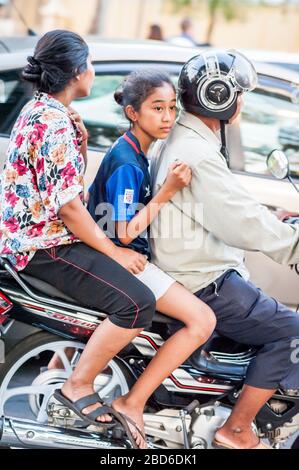 Une famille fait leur chemin à travers les rues animées de Phnom Penh sur une moto. Banque D'Images