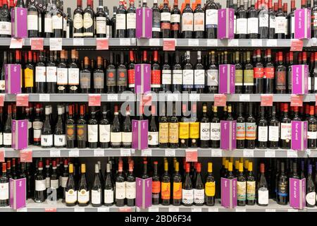Bouteilles de vin rouge en démonstration sur les étagères à vendre avec des étiquettes de pays d'origine au supermarché Waitrose, Royaume-Uni. Thème - alcool, alcoolisme, toxicomanie Banque D'Images