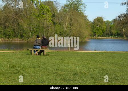 Wanstead Park, Londres, Royaume-Uni - 07 avril 2020: Un coupé profiter du temps chaud à Wanstead Park tout en observant les distanciation sociale sur un mardi après-midi ensoleillé pendant le lock-down britannique. Le gouvernement a conseillé au public de rester chez lui à travers le Royaume-Uni en raison de la pandémie de Covid-19, mais pour des voyages essentiels pour les bases et l'exercice. Photos: David Mbiyu/ Alay Live News Park tout en observant les distanciation sociale sur un mardi après-midi ensoleillé pendant le lock-down du Royaume-Uni. Le gouvernement a conseillé au public de rester chez lui à travers le Royaume-Uni en raison de la pandémie de Covid-19, mais pour les voyages essentiels pour les bases et les exercices Banque D'Images