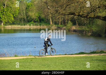Wanstead Park, Londres, Royaume-Uni - 07 avril 2020: Les gens font du vélo dans Wanstead Park tout en observant des distanciation sociale sur un mardi après-midi ensoleillé pendant le Lockdown du Royaume-Uni. Le gouvernement a conseillé au public de rester chez lui à travers le Royaume-Uni en raison de la pandémie de Covid-19, mais pour des voyages essentiels pour les bases et l'exercice. Photos: David Mbiyu/ Alay Live News Banque D'Images