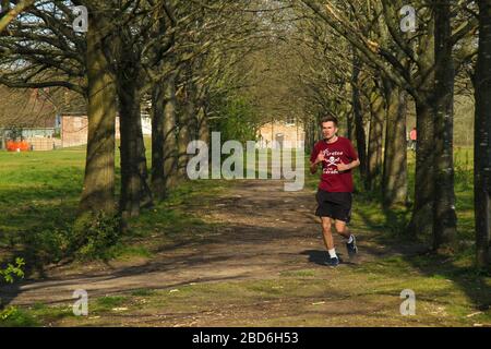 Wanstead Park, Londres, Royaume-Uni - 07 avril 2020: Un homme de jogs à Wanstead Park tout en observant des distanciation sociale sur un mardi après-midi ensoleillé pendant le Lockdown britannique. Le gouvernement a conseillé au public de rester chez lui à travers le Royaume-Uni en raison de la pandémie de Covid-19, mais pour des voyages essentiels pour les bases et l'exercice. Photos: David Mbiyu/ Alay Live News Banque D'Images