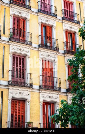 Vue sur un élégant balcon avec volets rouges sur le côté d'un immeuble d'appartements d'époque Banque D'Images