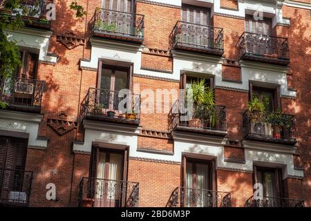 Vue sur un élégant balcon avec volets sur le côté d'un bâtiment d'époque en brique rouge Banque D'Images