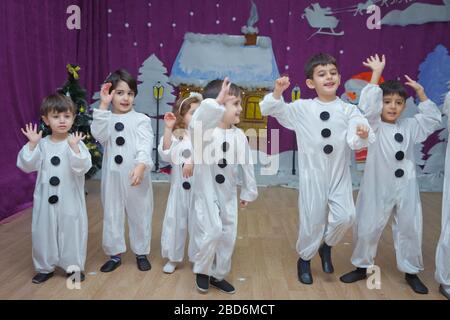 Les enfants sont habillés comme des bonhommes de neige. Les participants à la maternelle participent à un événement du nouvel an. Mignons garçons vêtus de costumes festifs du Père Noël Banque D'Images