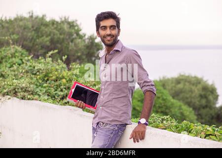 un homme de bonne taille dans la ville qui tient une tablette Banque D'Images