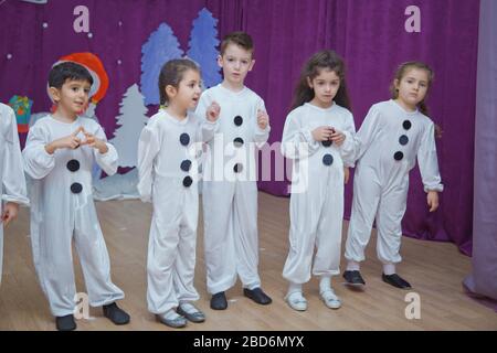 Les enfants sont habillés comme des bonhommes de neige. Les participants à la maternelle participent à un événement du nouvel an. Mignons garçons vêtus de costumes festifs du Père Noël Banque D'Images