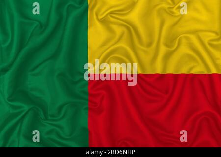 Drapeau de pays du Bénin sur fond de tissu de soie ondulé. Banque D'Images