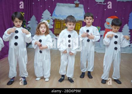 Les enfants sont habillés comme des bonhommes de neige. Les participants à la maternelle participent à un événement du nouvel an. Mignons garçons vêtus de costumes festifs du Père Noël Banque D'Images