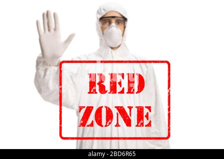 Texte écrit zone rouge et un homme dans un costume blanc hazmat et masque gestuelle arrêt isolé sur fond blanc Banque D'Images
