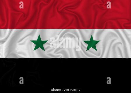 Drapeau de pays de Syrie sur fond de tissu en soie ondulé. Banque D'Images